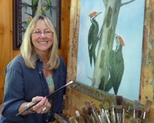 Susan Parmenter in her studio painting "Pileated Pair"