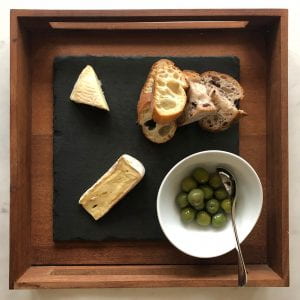 a plate or cheese, olives and slices of bread