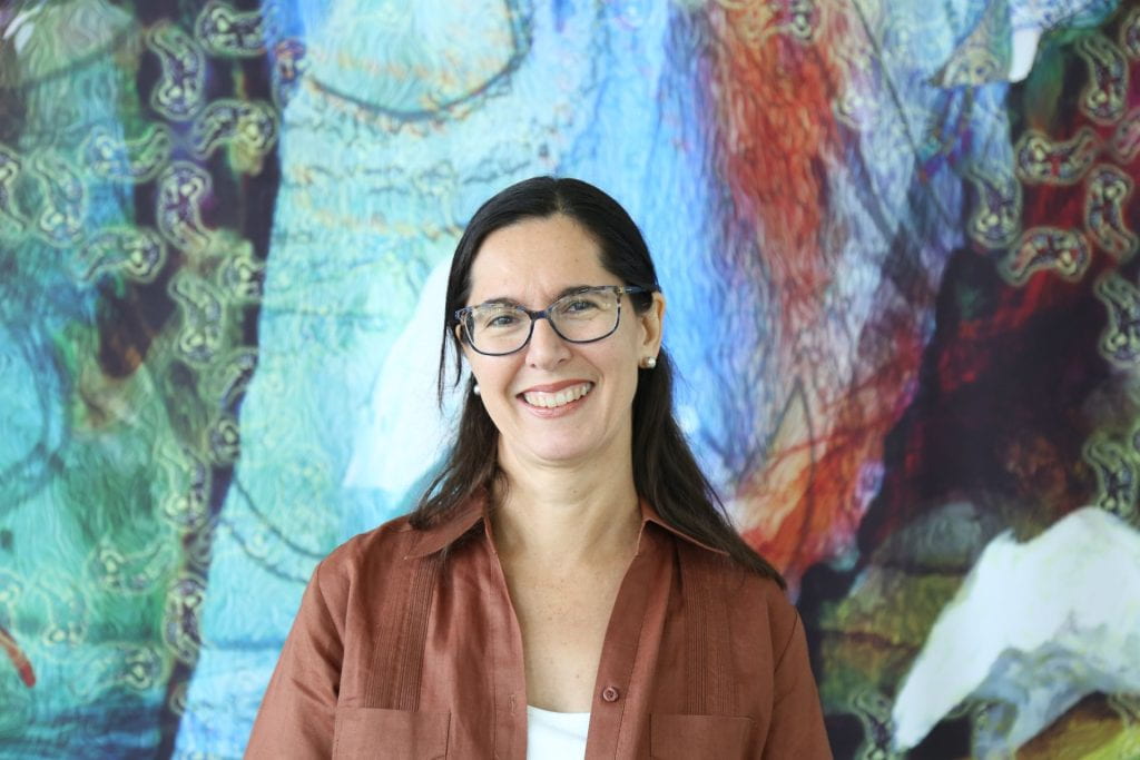 Headshot of Prof. Christina Civantos smiling in front of mural.