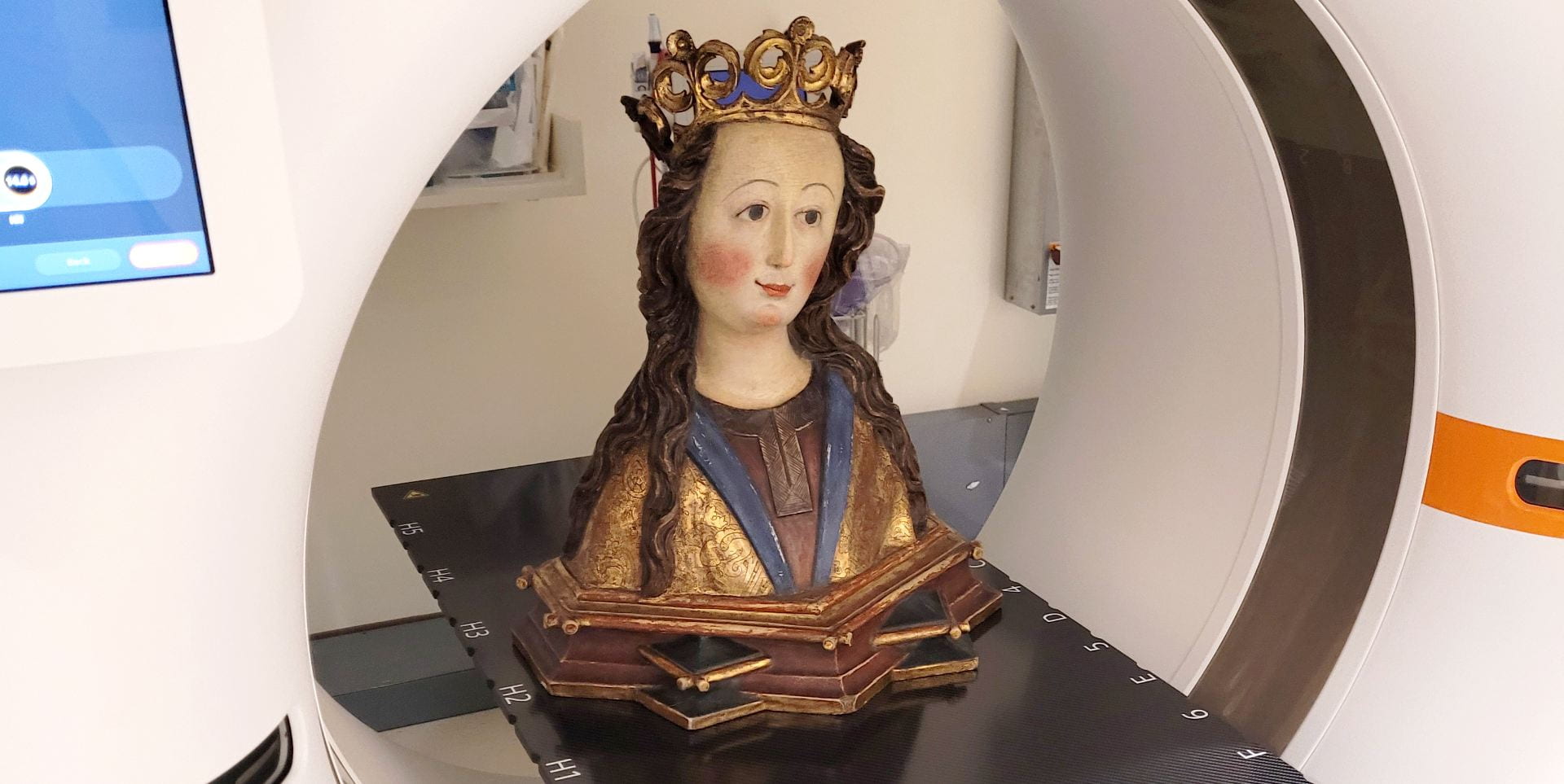 A religious relic in the form of a bust of a woman wearing a crown inside a CT scanner.